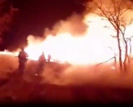 Large area of fire with figures in the foreground