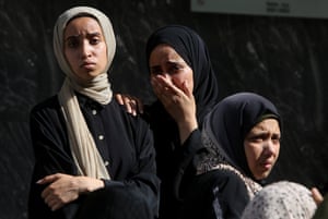 Woman stand with stricken expressions, one of them crying