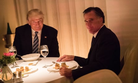 Donald Trump, left, and Mitt Romney, right, sit at a round table made with a white tablecloth, eating scallops and drinking water out of wine glasses. Both men are white and wearing suits.