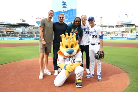 Dan Burn, Harry Kane, Djed Spence and Thomas Tuchel pose for a photograph alongside mascot Sluggerrr and Matt Quatraro, manager of the Kansas City Royals