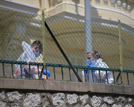 Investigators examine the scene at the residential building where an explosive device seriously injured three people a day earlier in Monaco.