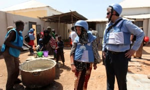 United Nations personnel look on as a worker serves food at a camp in Hodan district in Mogadishu.