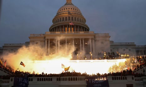 Image of the US Capitol, lit up by the light of an explosion, with a mob gathered around it