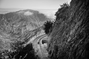An Eritrean girl walks along railway tracks winding through steep mountains near Massawa