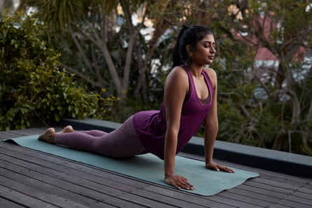 Young woman practicing cobra pose yoga with eyes closed