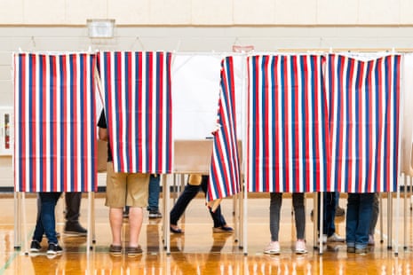 people stand in voting booths
