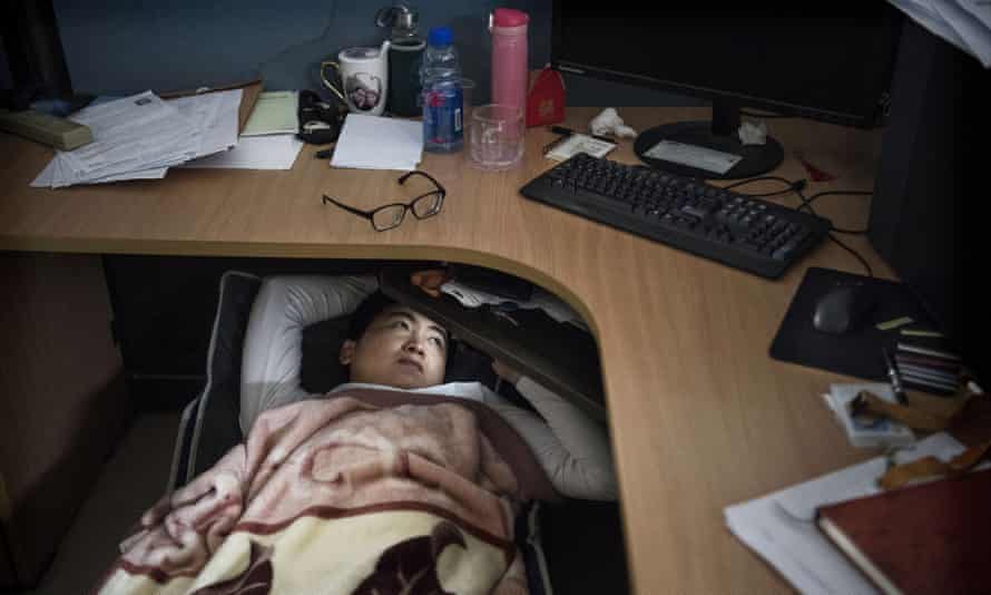 A Huawei employee rests in his cubicle in the research and development area at the Bantian campus in Shenzen, 12 April