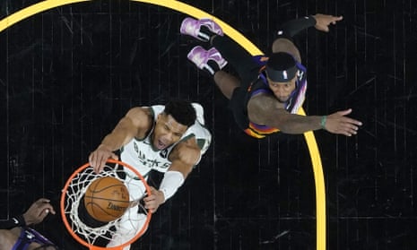 Giannis Antetokounmpo dunks as Phoenix Suns forward Torrey Craig, right, looks on during the first half of Game 1 of the NBA finals