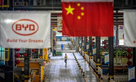 A Chinese flag hangs over the factory floor at Chinese carmaker BYD