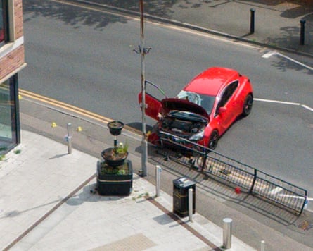 Crashed red car facing the kerb.