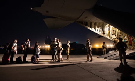 People line up to board the first Australian Defence Force evacuation flight at night in Kabul, Afghanistan in August 2021