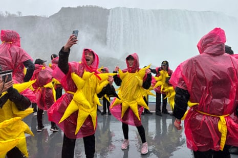 Some of the 309 people gathered to break the Guinness world record for the largest group of people dressed as the sun pose on a sightseeing boat, before the total solar eclipse in Niagara Falls, Ontario, Canada.