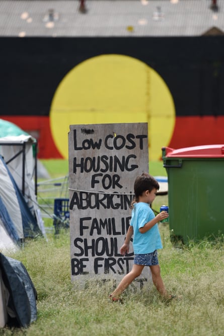 A young boy walks past a sign at the Redfern Aboriginal tent embassy in Sydney, Monday, Feb. 23, 2015.