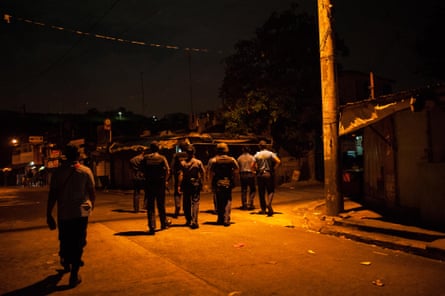 Police patrol a shanty community late at night in September 2016 in Manila