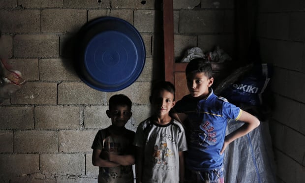 Syrian refugee children stand inside a commercial space that a family has rented to live in, in a neighborhood of the city of Gaziantep, Turkey