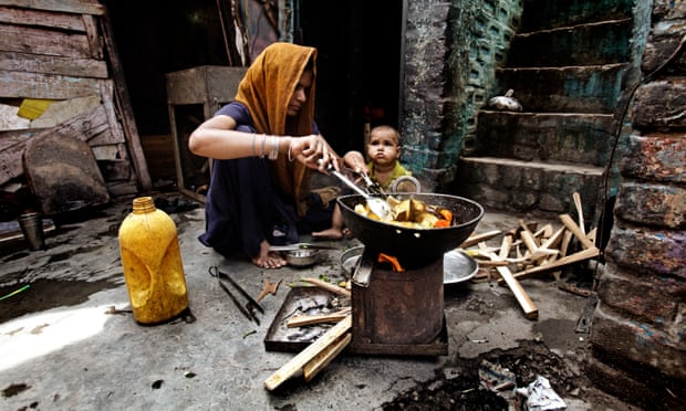 A woman cooks vegetables in palm oil outside her house in Delhi, India.