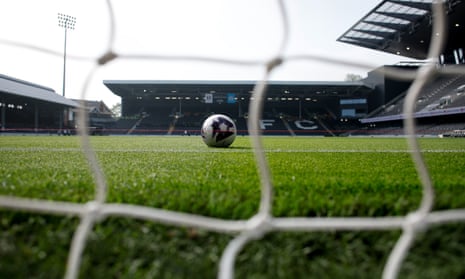 A football sits on the pitch inside Craven Cottage