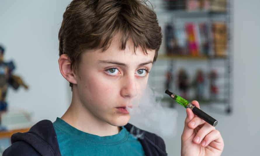 A teenager smoking an e-cigarette.