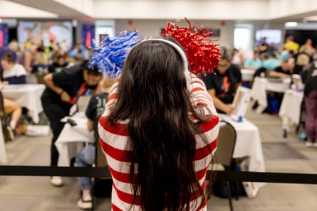 A woman with blue and red pom poms cheers
