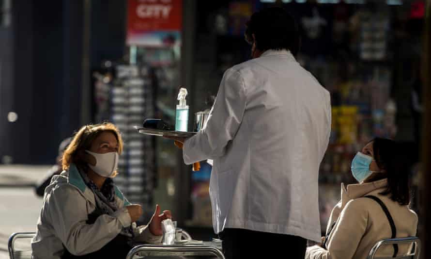 A waiter at a cafe attends to guests in Barcelona