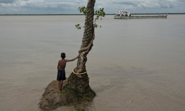 A child looking at a ship is pictured on June 11, 2016 in Ghoramara Island, India. Ghoramara Island is an island 92 km south of Kolkata, in the Sundarban Delta complex of the Bay of Bengal. The island is roughly five square kilometers in area, and is quickly disappearing due to erosion and rise in sea level.