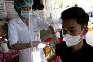 A Cambodian man, right, receives a shot of fourth dose of the Pfizer’s Covid vaccine at a heath centre in Phnom Penh, Cambodia.