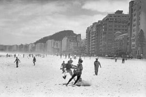 A group of workers play football on Copacabana Beach, within sight of some of Rio’s most expensive housing and hotels.