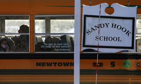 A school bus drives past a Sandy Hook school sign in Newtown, Connecticut.