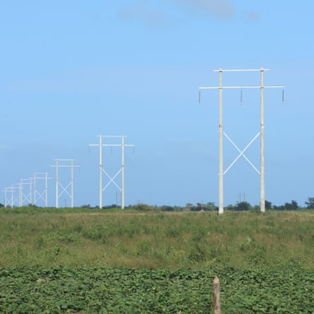 Electricity pylons stretch into the distance in a rural landscape