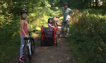 Chris Hall and his two young daughters with bikes on a woodland trail