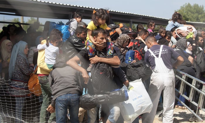 Migrants and refugees try to break through a cordon of Macedonian police forces to board a train after crossing the Macedonian-Greek border near the Macedonian town of Gevgelija.