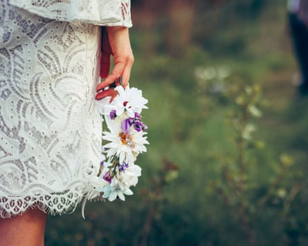 Bride’s hand holding flowers