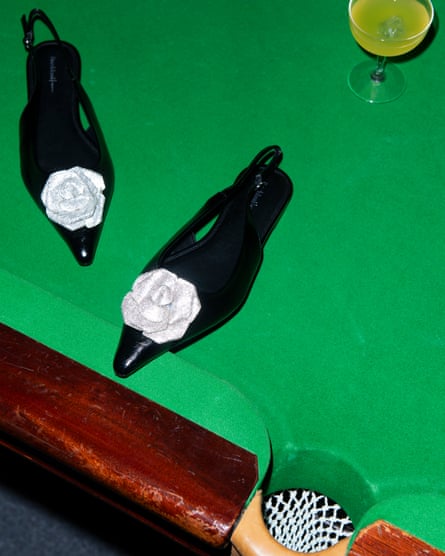 Black court shoes with silver flowers - photo taken on a snooker table