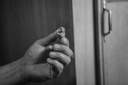 A hand holds an oily plug filter