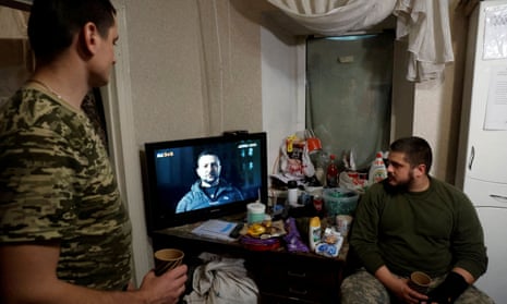 Ukrainian soldiers watch Volodymyr Zelenskiy’s New Year’s Eve address, in a military rest house in Donetsk.