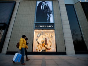 People walk past the window display of a Burberry store in Beijing.