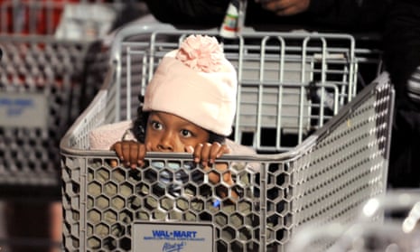 Nevaeh Enoch, 6, peers out from a shopping cart while waiting for a Wal-Mart to open around 5 a.m. Friday, Nov. 28, 2008, in Oakland, California, USA. Hoping for deals on clothes and toys, Enoch and her mom joined the line of several hundred people at 2:45 a.m. (AP Photo/Noah Berger)