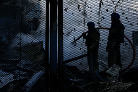 Firefighters work at a site damaged during a Russian missile strike in Kyiv.