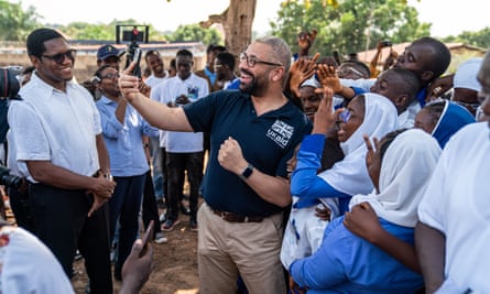 Cleverly surrounded by schoolchildren as he takes a selfie in Sierra Leone, March 2023