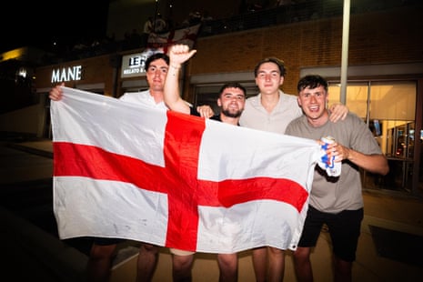 Four football fans hold up an England flag in Dallas, Texas