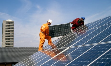 Engineers fitting solar panels to a roof