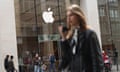 young woman carrying cellphone walks by Apple store