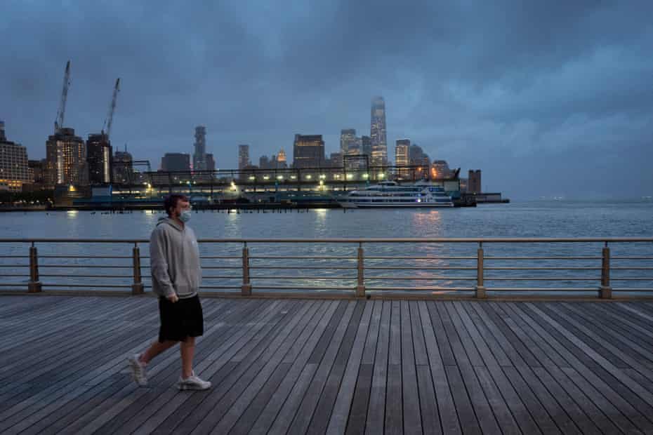 A young man wears a face mask as he walks on Pier 45 in Hudson River Park in New York in April.
