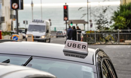 A car parked near the seafront with an Uber sign on its roof like a traditional taxicab sign
