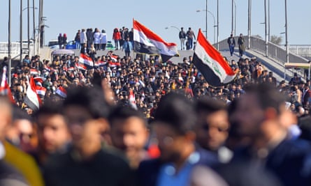 Iraqi students hold national flags during an anti-government demonstration in the central Iraqi city of Najaf.
