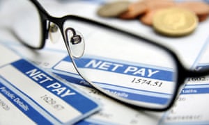 a pair of spectacles rest atop a payslip
