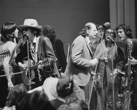 Women and men in black and white photo singing on stage