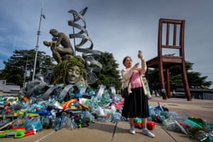 A woman takes a selfie in front of artwork by Canadian artist Benjamin Von Wong