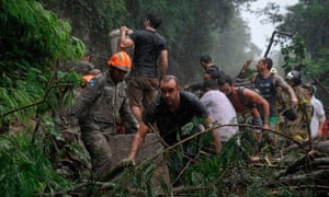 Firefighters and others take part in a rescue operation after heavy rains in Rio de Janeiro.