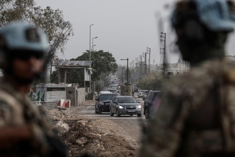 UN peacekeepers stand guard as displaced people make their way back home in southern Lebanon